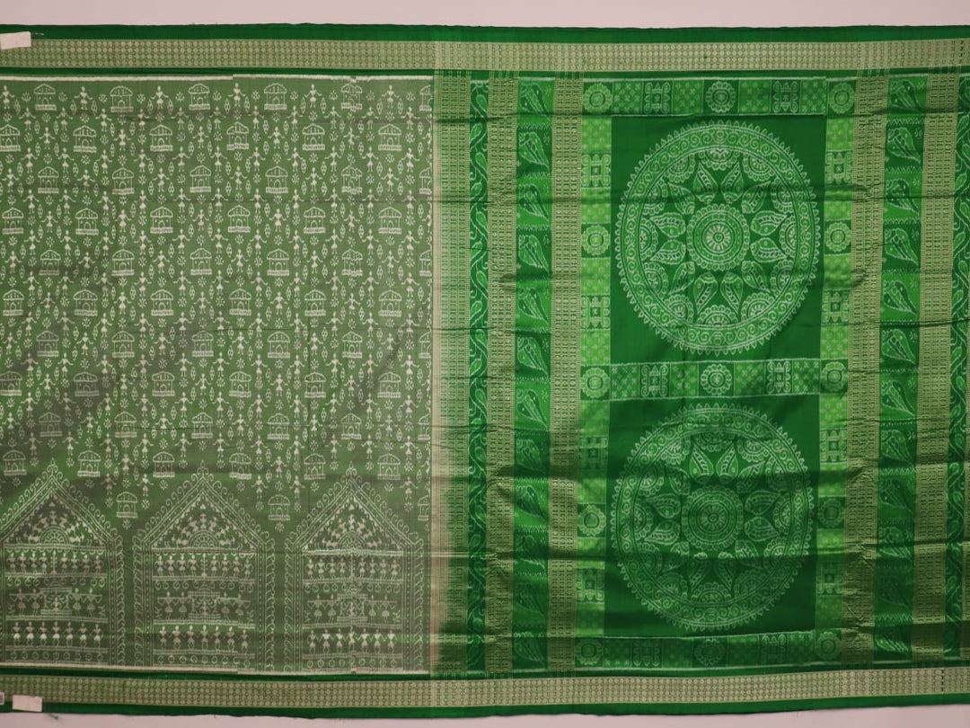 Close-up view of the intricate silk fabric texture of a green Sambalpuri silk saree with traditional motifs.