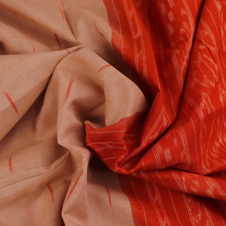 Cream and orange Sambalpuri cotton saree draped, showcasing traditional motifs and handloom texture.