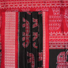 Close-up showing the luxurious texture and fine weave of the black Sambalpuri silk fabric.