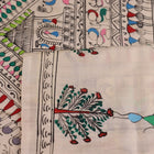 Close-up of the white silk saree fabric texture, showcasing the handloom weave and painted Patachitra details.