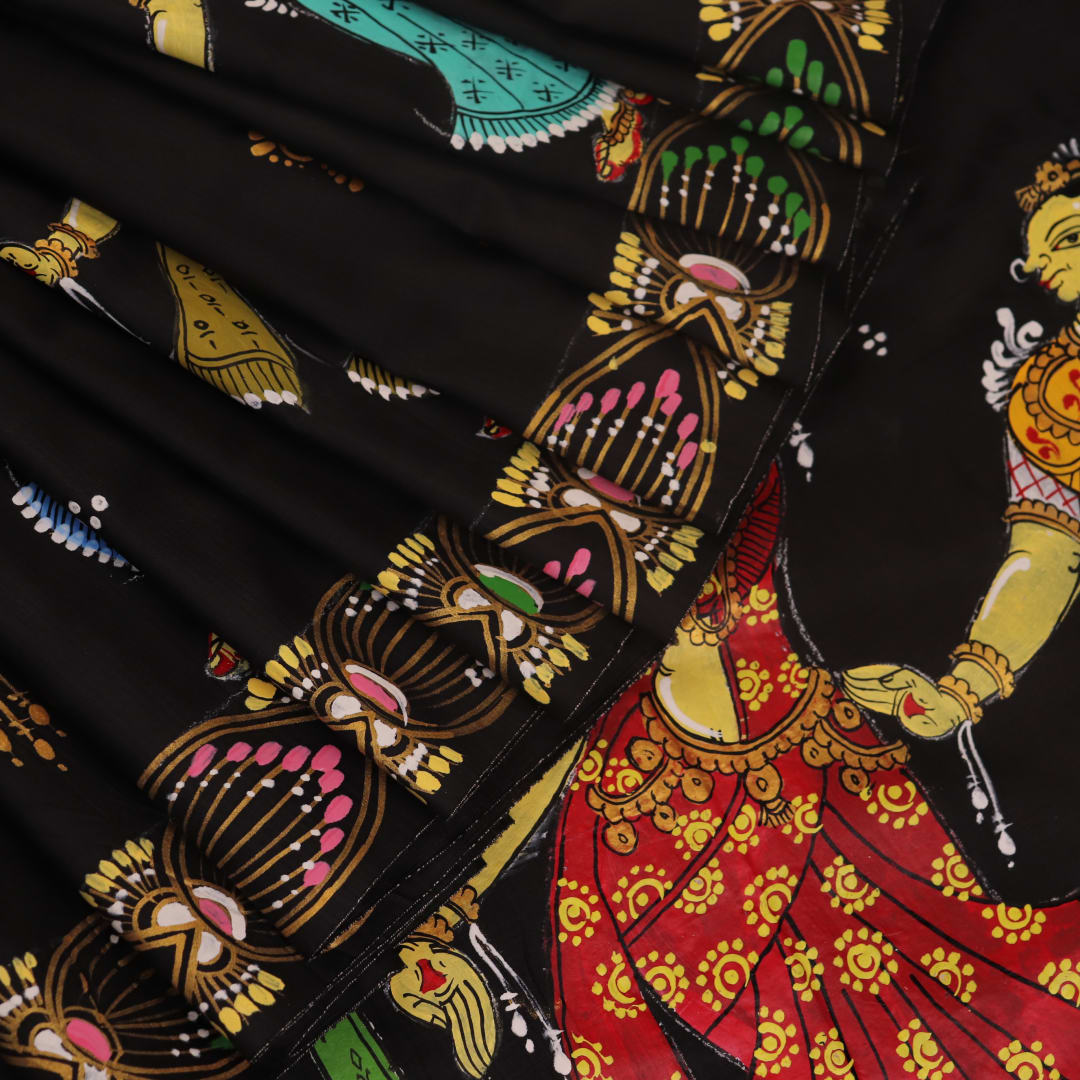 Close-up of black silk Patachitra saree fabric, showcasing hand-painted texture and detail.