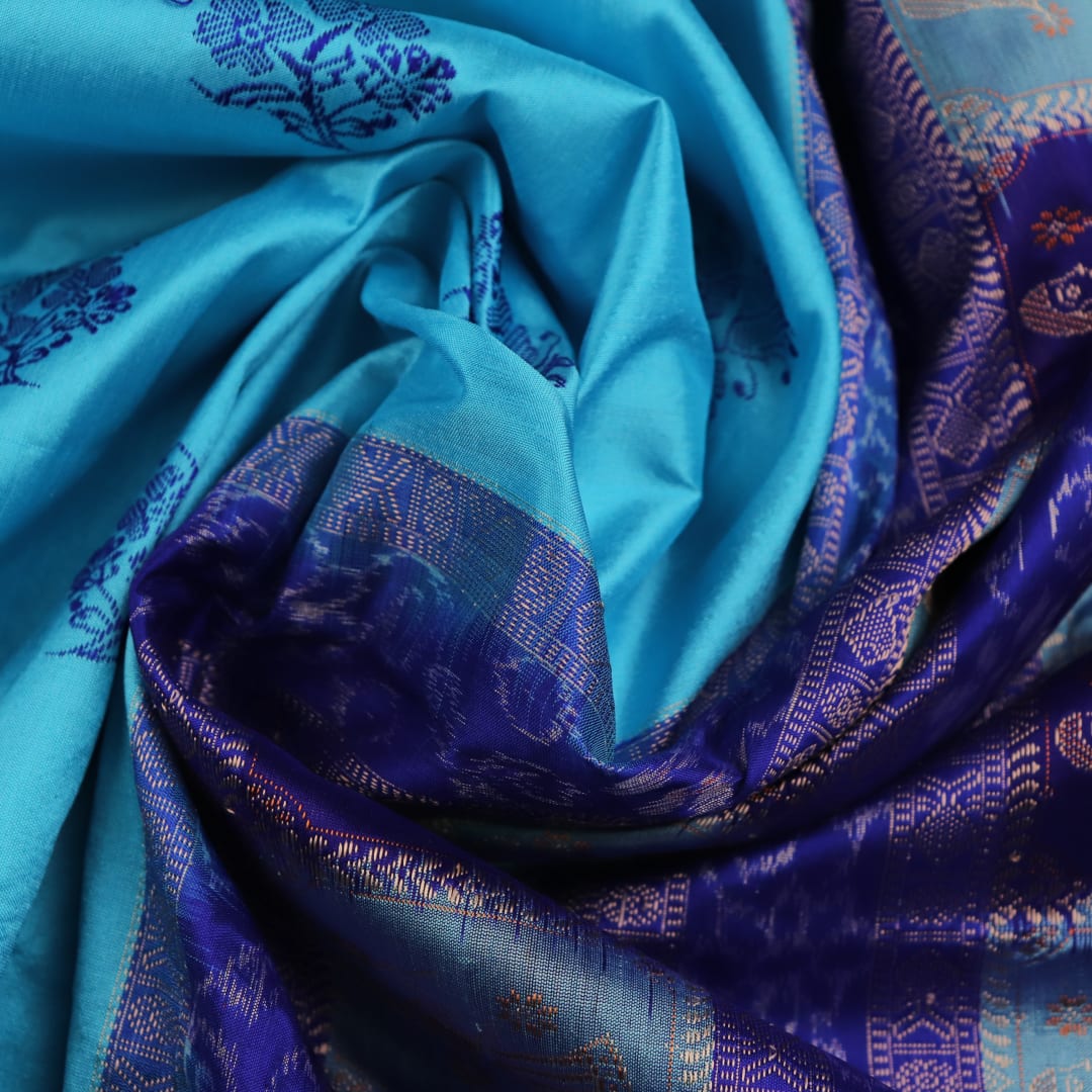 Close-up showcasing the silk texture of a blue and blue Bomkai silk saree with a butta pattern.