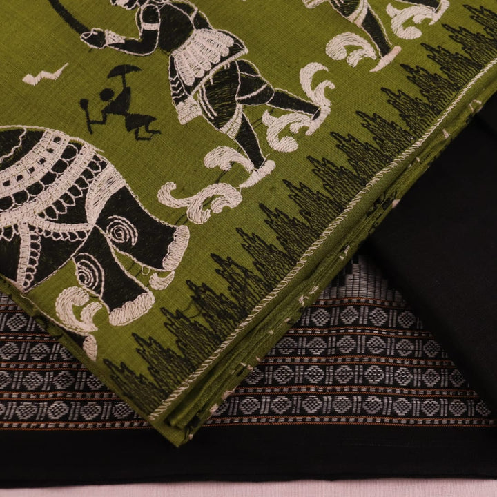 Close-up showcasing the Sambalpuri doll pattern on the green cotton dress material.