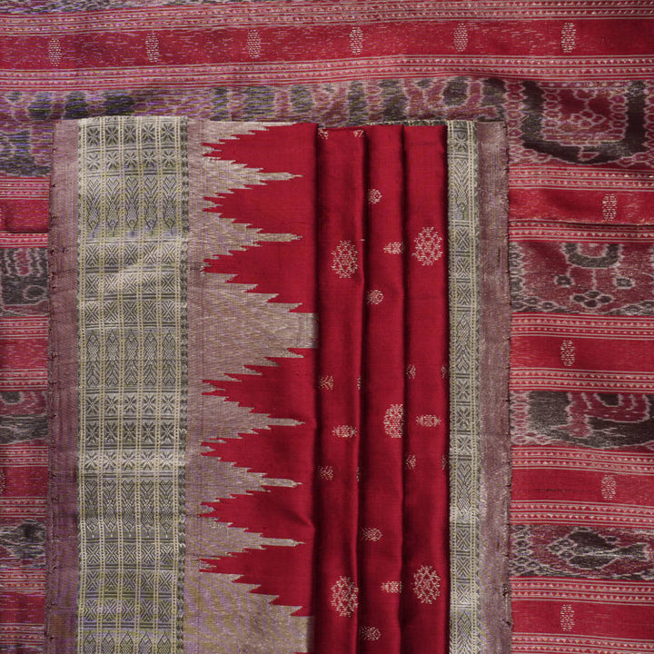 Extreme close-up revealing the rich texture and intricate handloom weave of the maroon and grey Sambalpuri silk fabric.