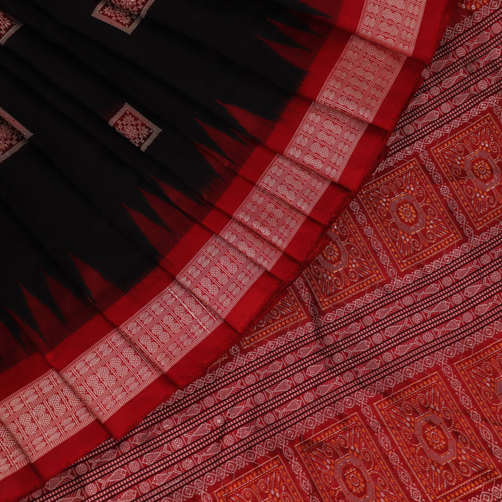 Close-up of black and red silk Sambalpuri saree fabric showcasing intricate motifs