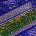 Close-up of green and blue Sambalpuri silk saree fabric showing intricate handloom weave and motif details.