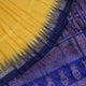 Textured close-up of yellow Bomkai silk saree fabric with blue butta pattern.
