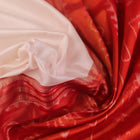 Close-up of white and red silk Bomkai saree fabric texture with butta pattern.