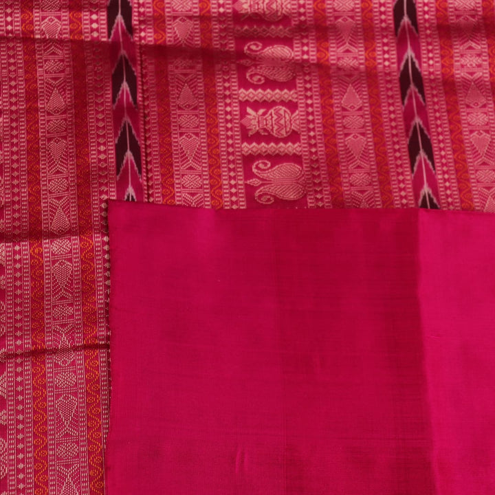 Close-up of green and magenta Bomkai silk saree fabric texture, highlighting intricate weave and butta pattern.