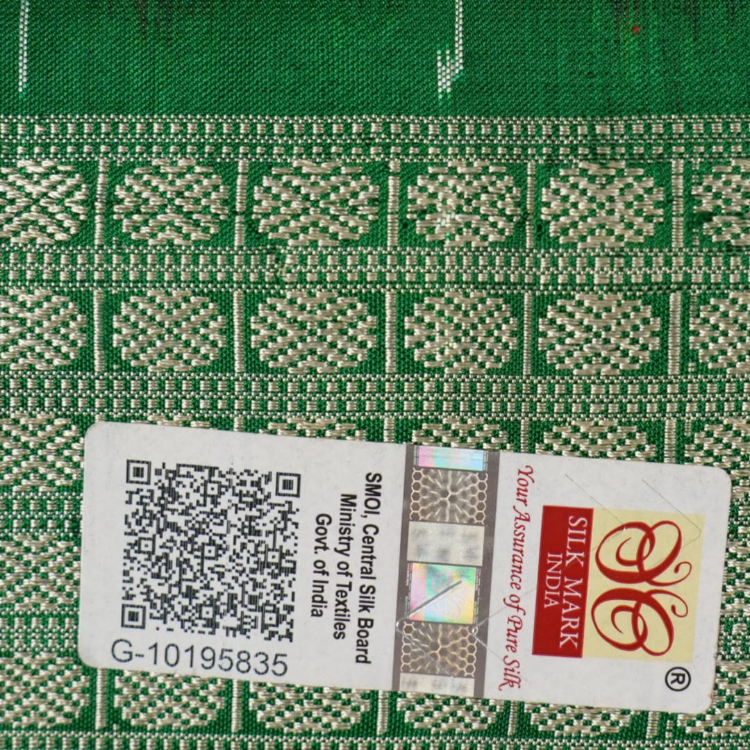 Close-up of the smooth, rich silk texture of the peach Sambalpuri saree with fine motifs.