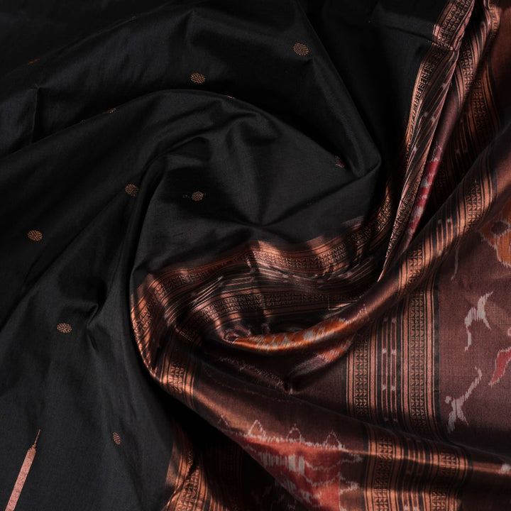 Extreme close-up showing the rich black and brown Sambalpuri Silk fabric texture and intricate handloom weave.