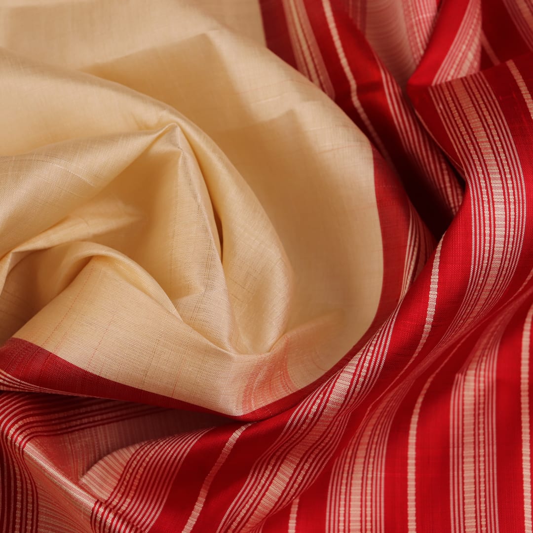 Close-up view of the intricate silk texture on a Berhampuri saree in white with a red border