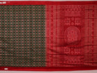 Close-up of green Sambalpuri silk saree fabric showing intricate woven motif texture and red thread details.