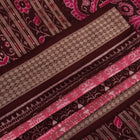 Close-up of peach and maroon Sambalpuri silk saree fabric showing intricate handloom texture and motifs.