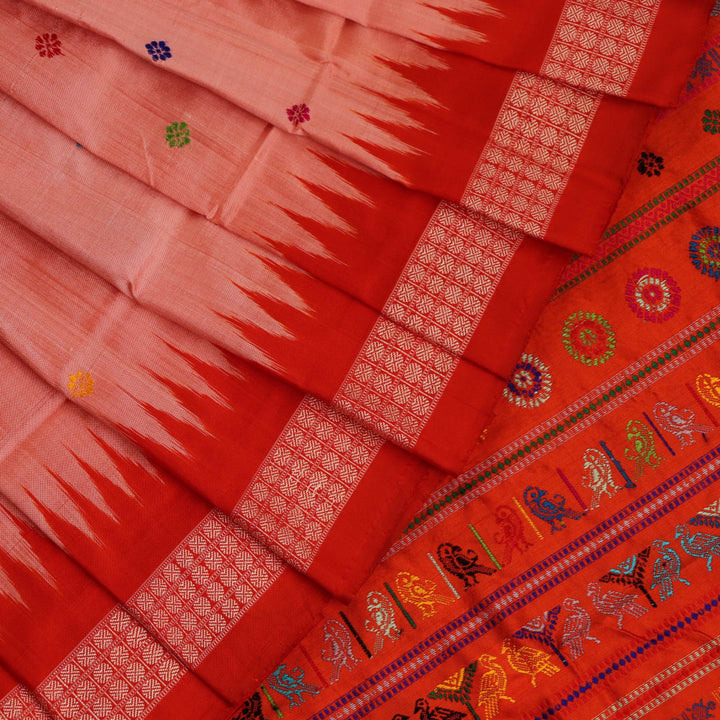 Close-up of finely woven silk fabric featuring intricate Butta patterns in multicolor with an orange accent