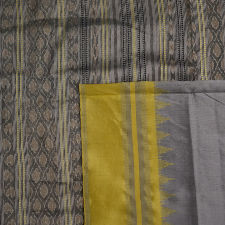 Close-up of the luxurious yellow Sambalpuri silk fabric, showing its fine weave and texture.