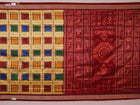 Close-up of multicolored Sambalpuri silk saree fabric texture showing intricate weave and maroon accents.
