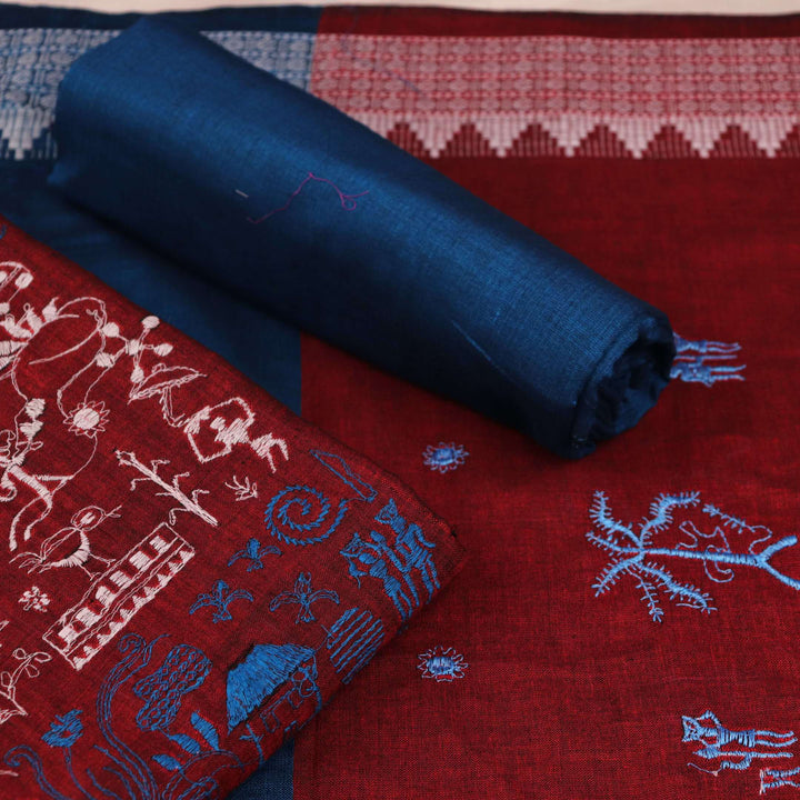 Close-up view of maroon and blue cotton Sambalpuri dress material, showcasing intricate doll pattern.