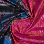 Close-up revealing the sheer tissue silk texture of the black saree, with subtle shimmering pink motifs.