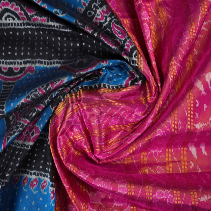Close-up revealing the sheer tissue silk texture of the black saree, with subtle shimmering pink motifs.