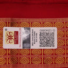 Close-up of white and red silk Bomkai saree fabric texture with butta pattern.