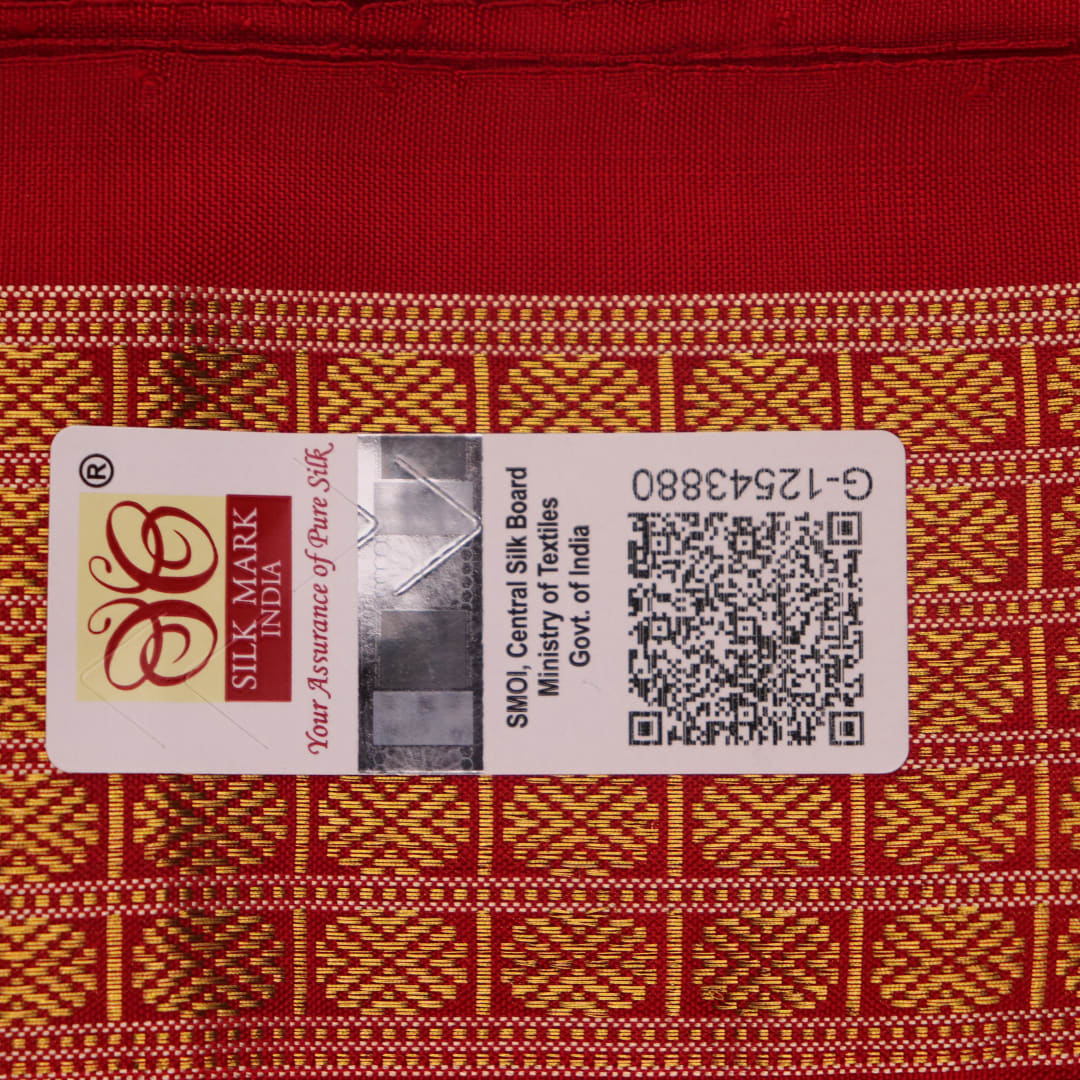 Close-up of white and red silk Bomkai saree fabric texture with butta pattern.