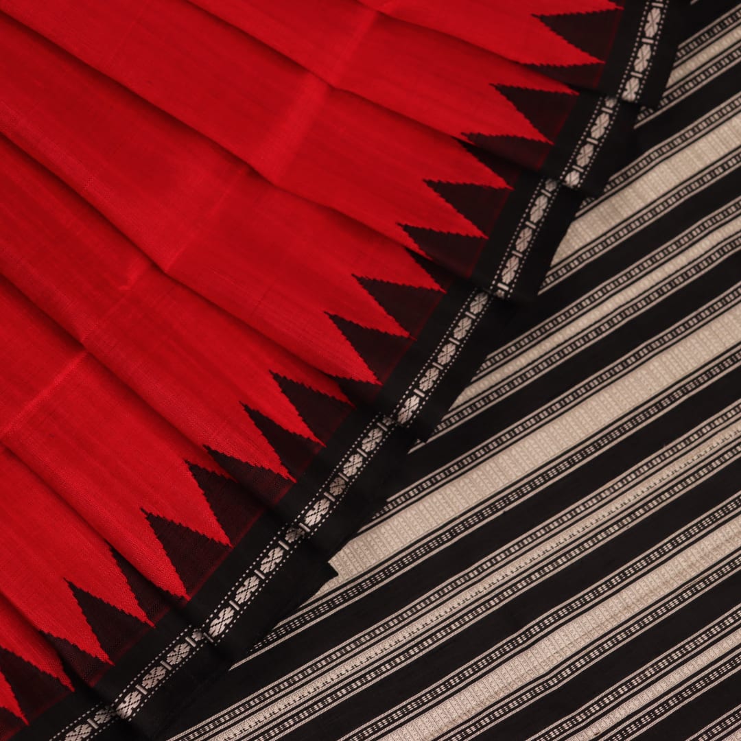 Close-up of the red and black plain silk fabric texture of a Berhampuri saree