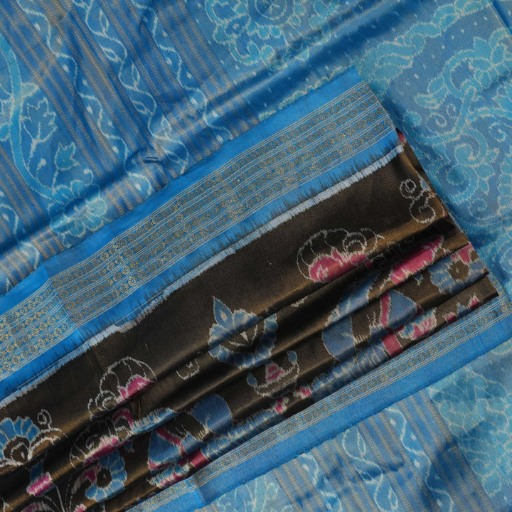 Close-up of Sambalpuri silk saree fabric, revealing rich blue multi-color weave texture and tissue motifs.