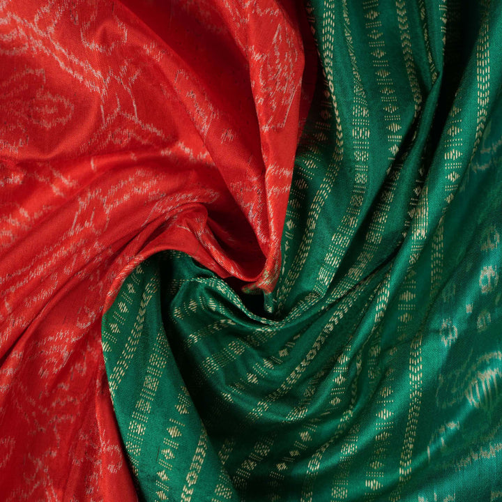 Extreme close-up of the rich orange Sambalpuri silk fabric, highlighting its intricate handloom weave texture.