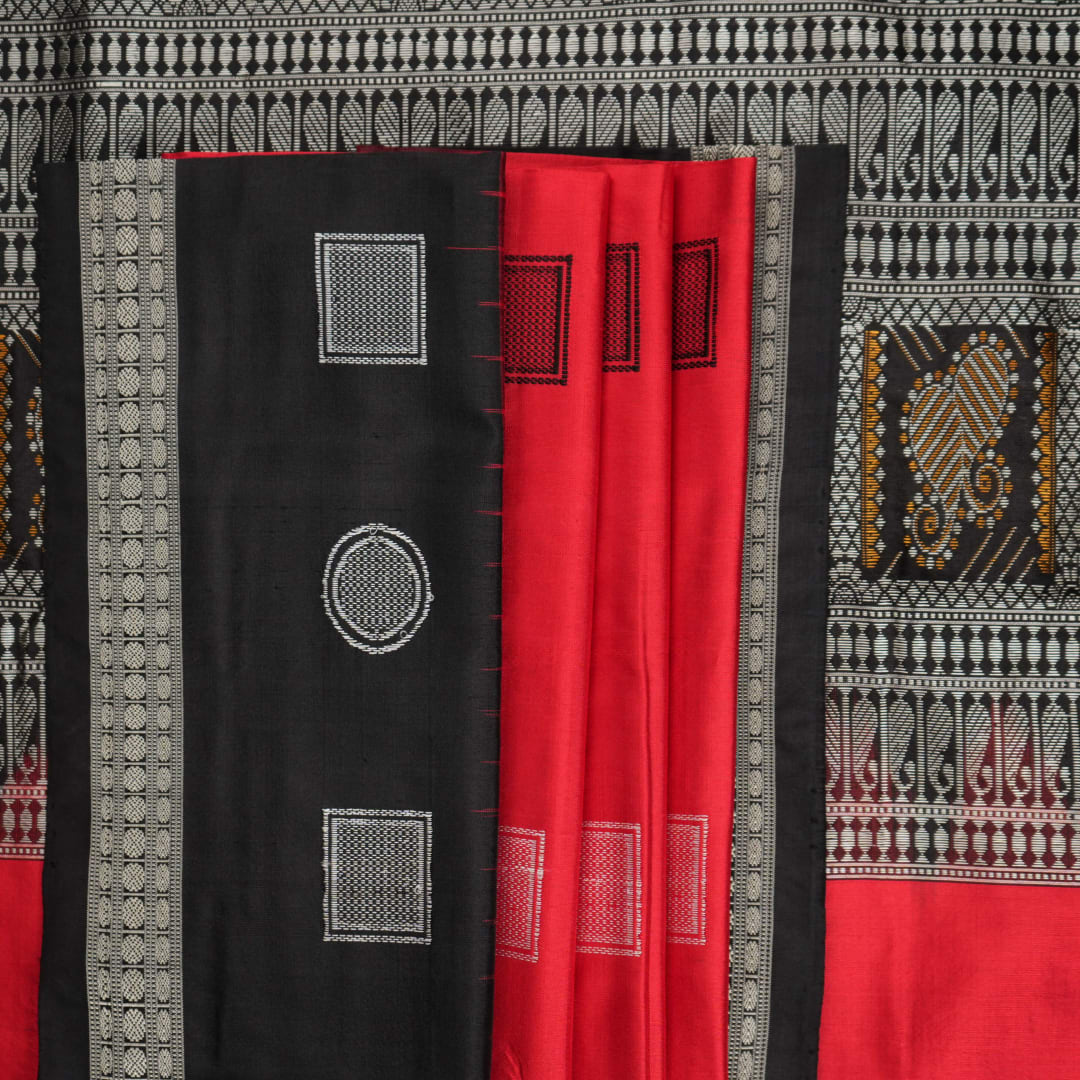 Extreme close-up of red Bomkai silk saree fabric showcasing rich texture and intricate weave.