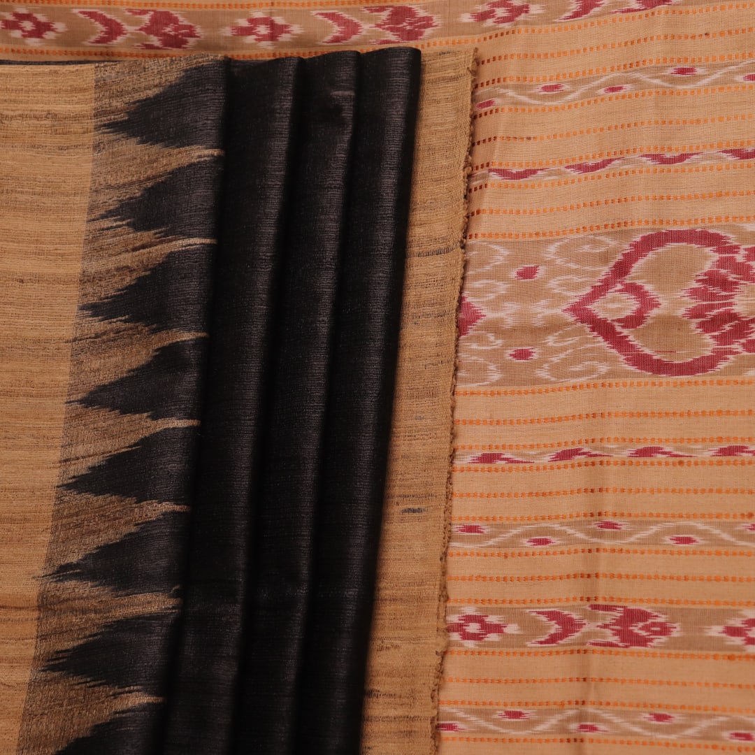 Close-up of black and cream tussar silk sari fabric showing the plain texture.