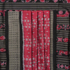Detailed close-up of the maroon and black Sambalpuri silk saree's luxurious fabric texture and weave.
