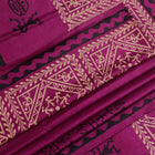 Close-up of magenta Tussar silk saree fabric, showing the printed pattern and natural slub texture.
