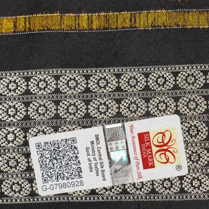 Close-up of the luxurious black Sambalpuri silk fabric, highlighting its rich texture and weave.
