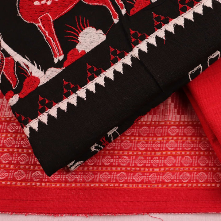 Close-up view of black and red cotton Sambalpuri dress material with doll pattern.