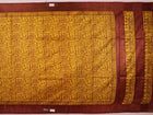 Close-up showing the textured weave of a yellow and brown printed Tussar silk saree.