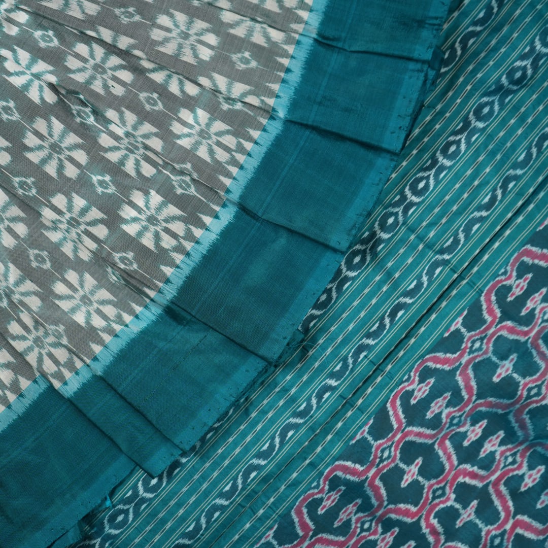 Close-up revealing the luxurious silk texture and subtle motif weave of the blue Sambalpuri saree.