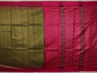 Close-up view of the luxurious texture of a plain green Tussar silk saree with a magenta border