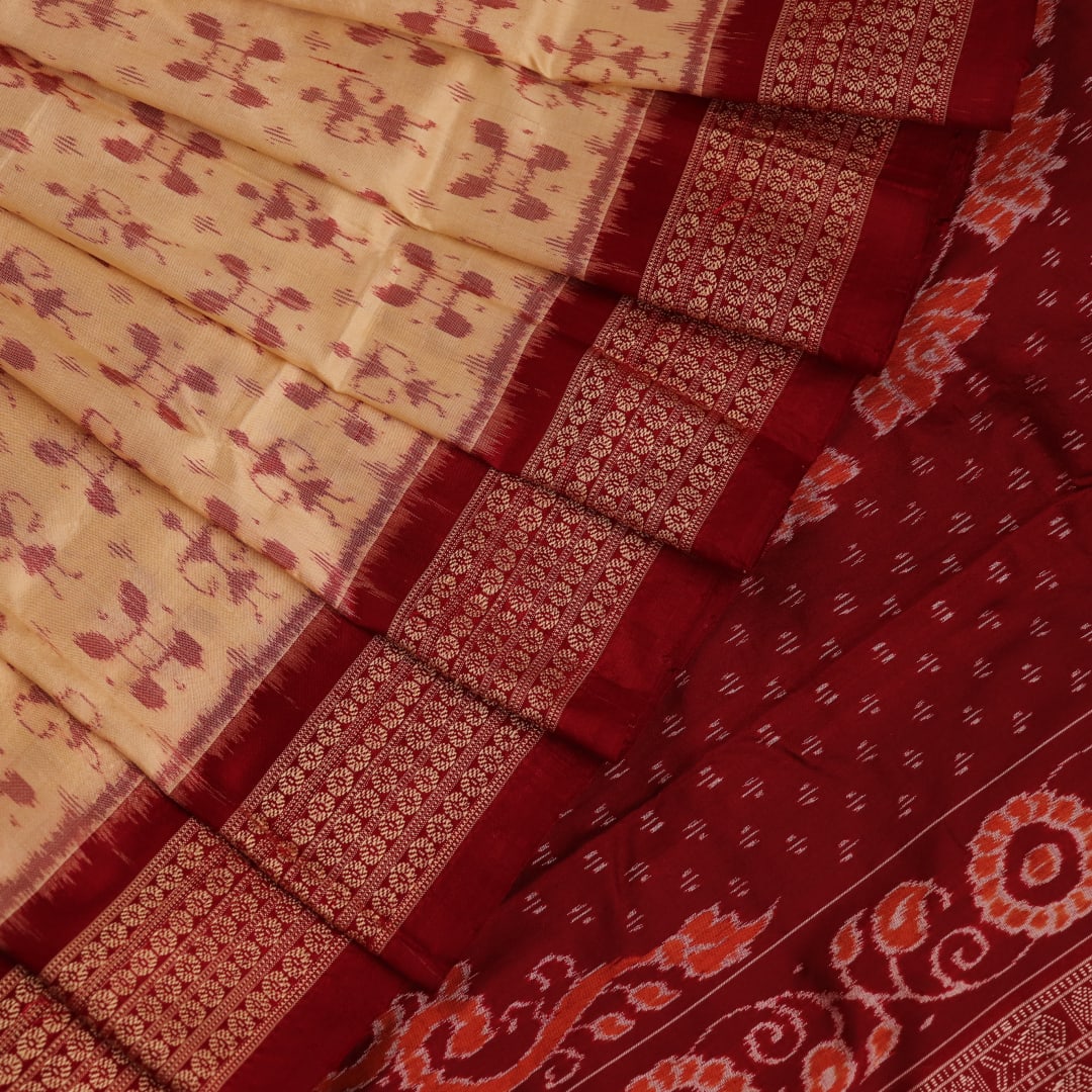 Close-up showcasing the intricate cream and maroon silk fabric texture with Sambalpuri motifs