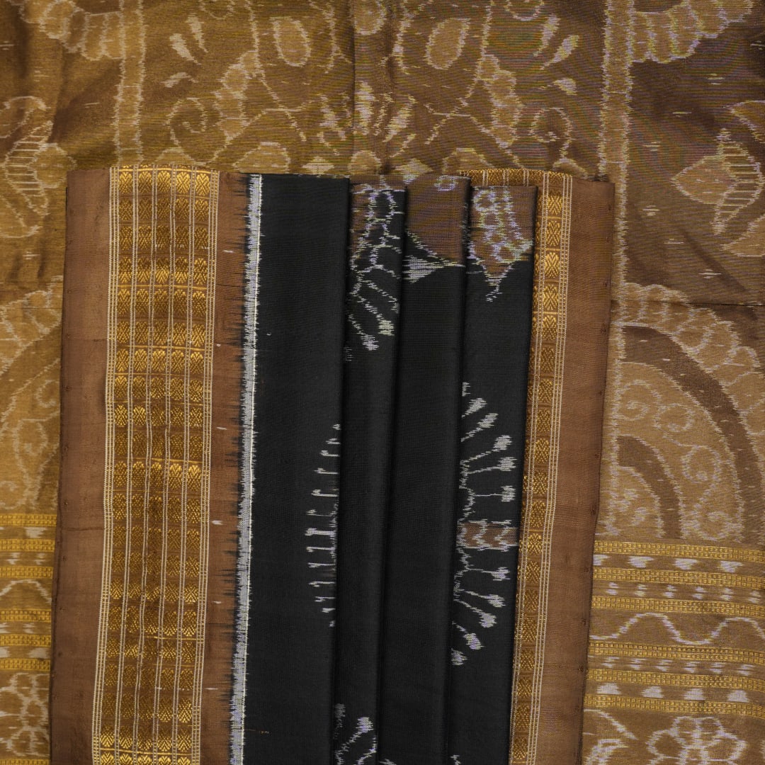 Close-up revealing the delicate, lustrous texture of the black silk tissue saree fabric with subtle sheen.