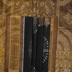 Close-up revealing the delicate, lustrous texture of the black silk tissue saree fabric with subtle sheen.
