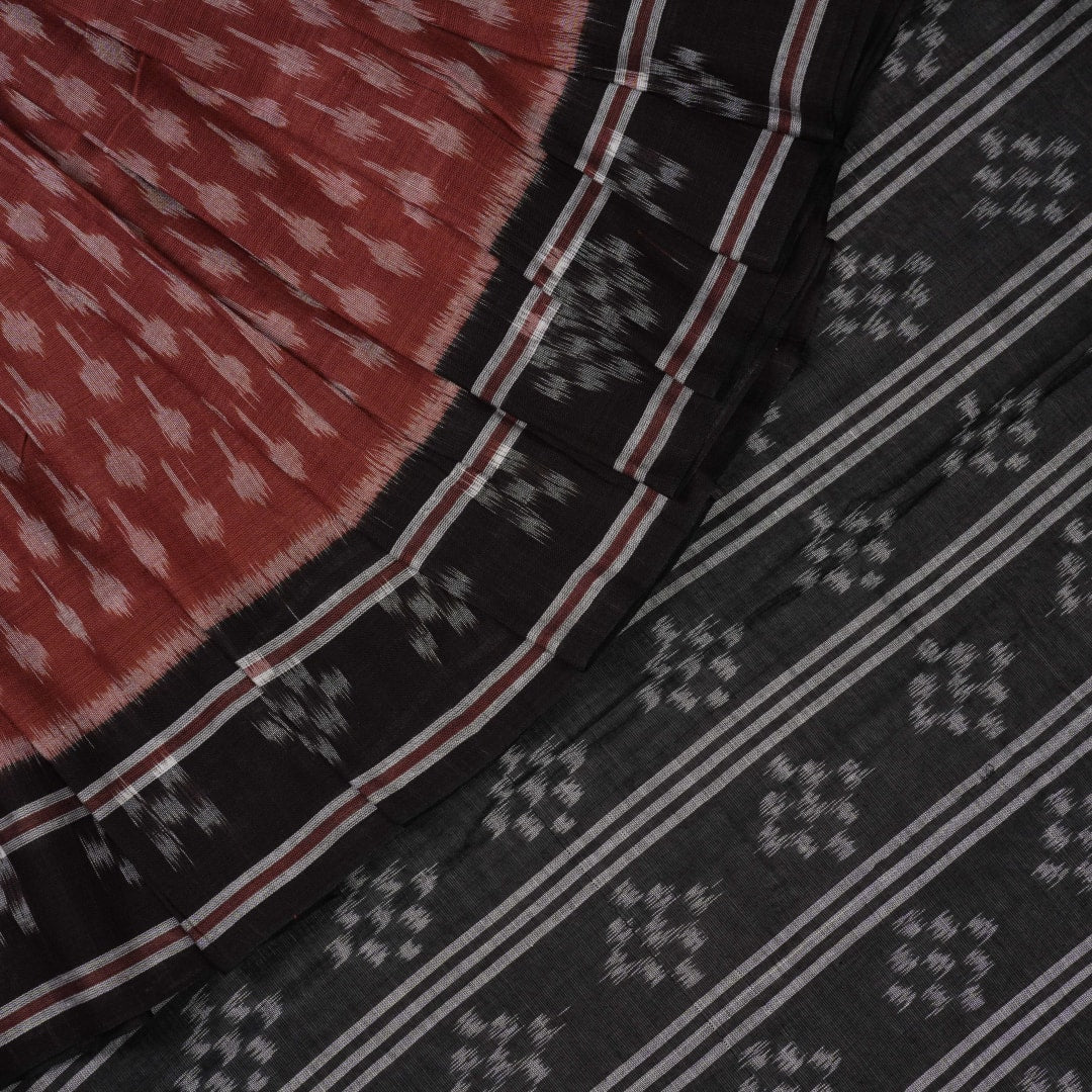 Full styling view of a model draped in a brown and black Sambalpuri cotton saree with traditional motifs.