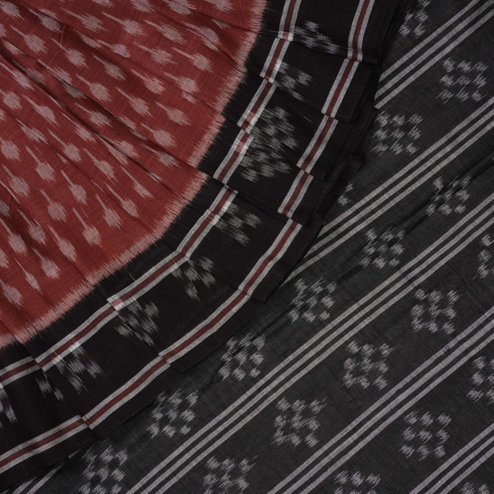 Full styling view of a model draped in a brown and black Sambalpuri cotton saree with traditional motifs.