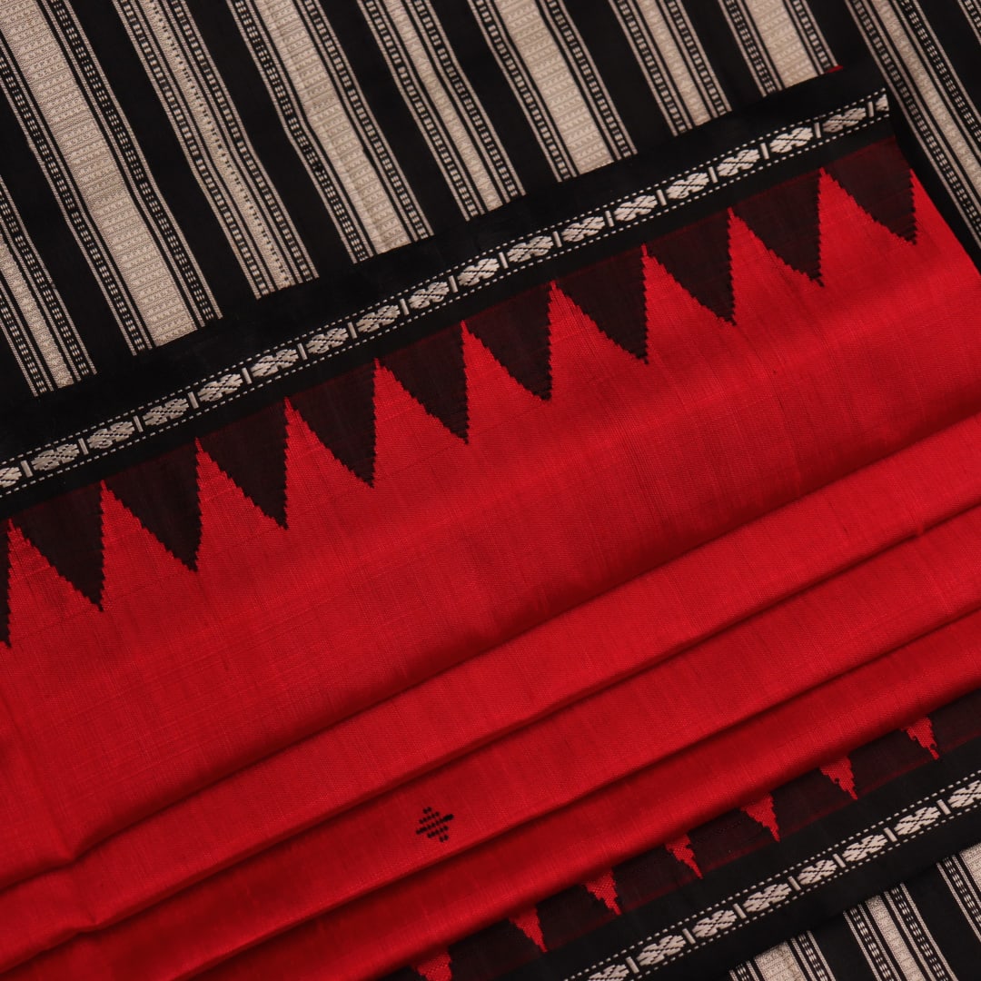 Close-up of the red and black plain silk fabric texture of a Berhampuri saree