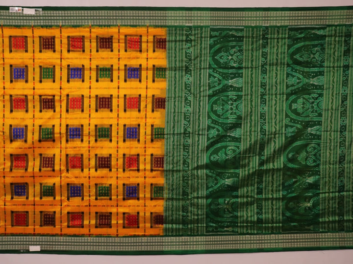 Close-up of yellow Sambalpuri silk saree fabric showing intricate motifs and woven texture.