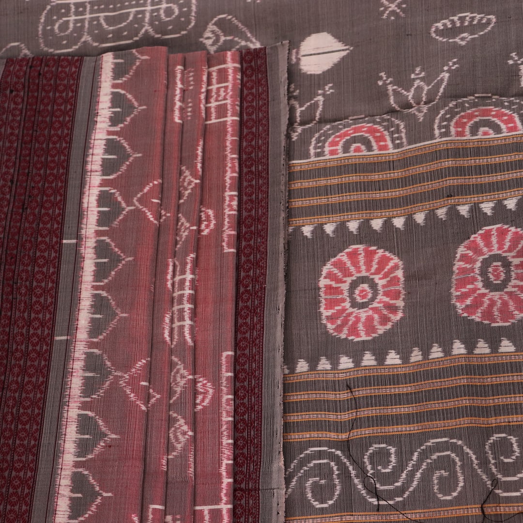 Close-up of a multicolored silk Sambalpuri saree fabric showing the intricate handloom texture and motifs.