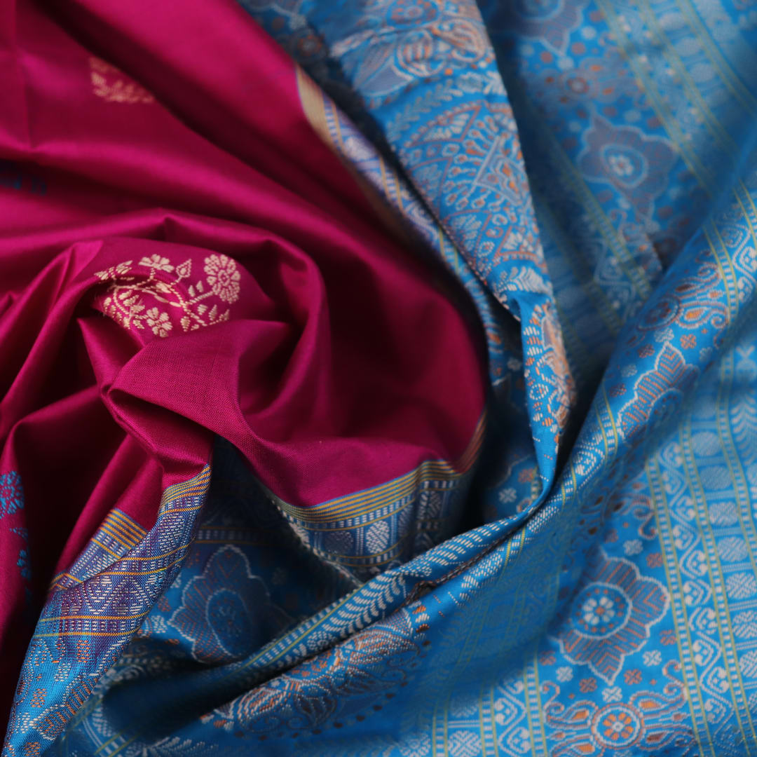 Close-up of Bomkai silk saree's textured weave, featuring magenta, blue, and butta pattern.