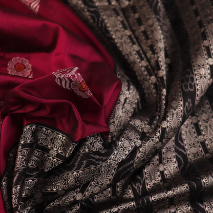 Close-up of magenta and black Bomkai silk saree texture, showing butta pattern weave.