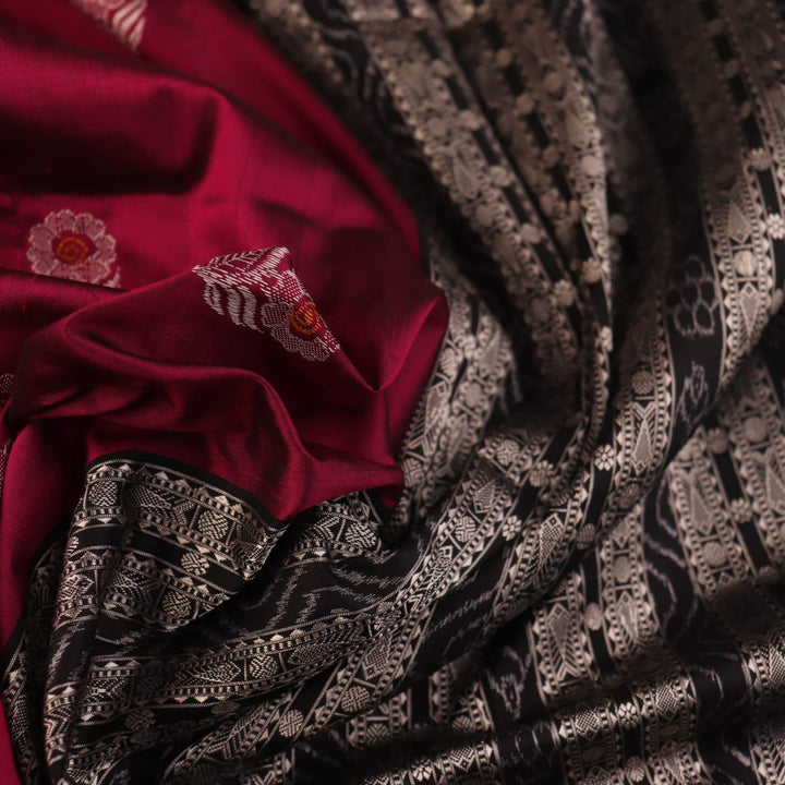 Close-up of magenta and black Bomkai silk saree texture, showing butta pattern weave.