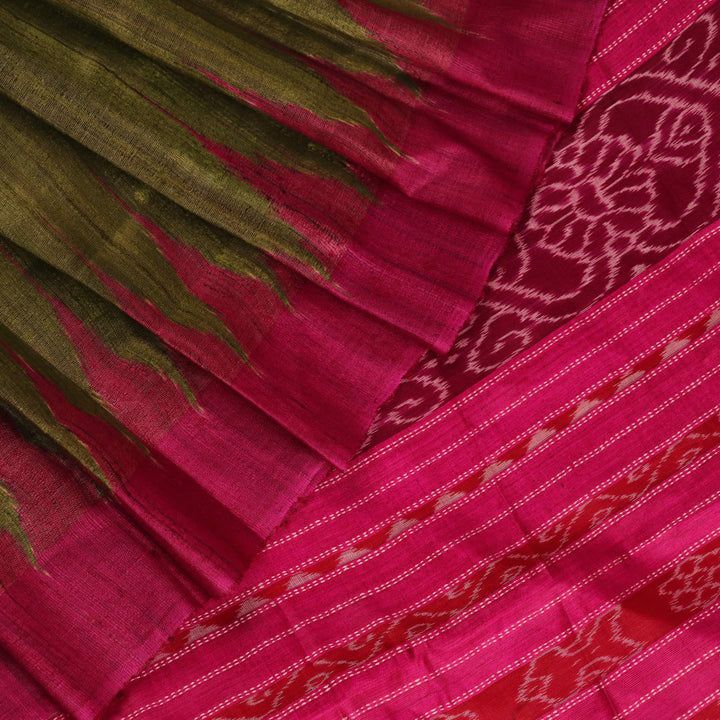 Close-up view of the luxurious texture of a plain green Tussar silk saree with a magenta border